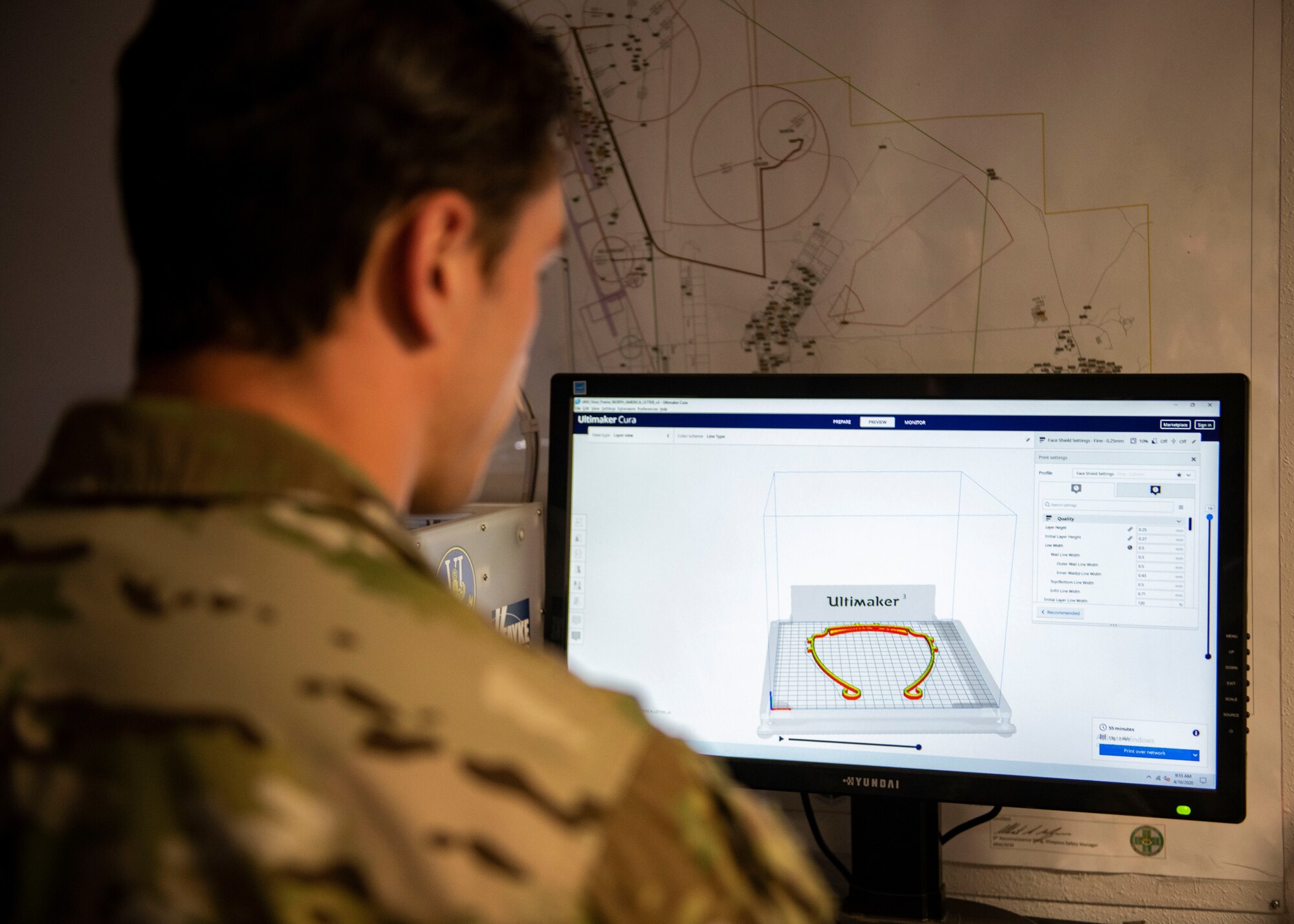 Senior Airman Jace Zook reviews the face shield design on a computer.