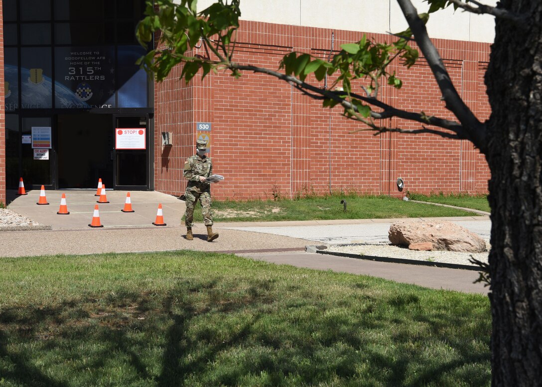 U.S. Air Force mission essential Airman from the 315th Training Squadron, leaves Di Tommaso Hall wearing a handmade mask on Goodfellow Air Force Base, Texas April 13, 2020. The installation limited base access to mission essential individuals, such as instructors and students, to eliminate the spread of COVID-19. Goodfellow members were directed under the Department of Defense to wear cloth face coverings when members couldn’t maintain six feet of social distance in public areas or work centers.   (U.S. Air Force Airman 1st Class Abbey Rieves)
