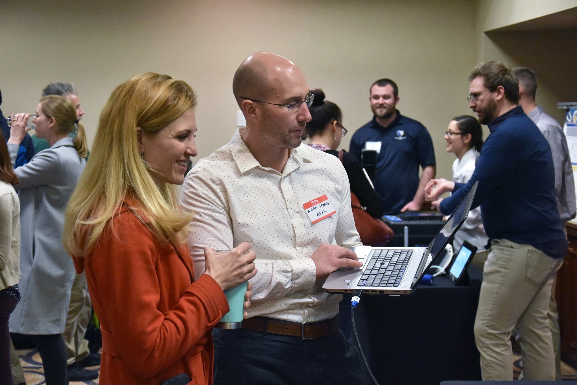 Dr. Adam Strang demonstrates Airman Data Analysis and Performance Tracking System to Dr. Jill McQuade, one of the Biotech Days organizers. Both are from the 711th Human Performance Wing. (U.S. Air Force photo/Spencer Deer)