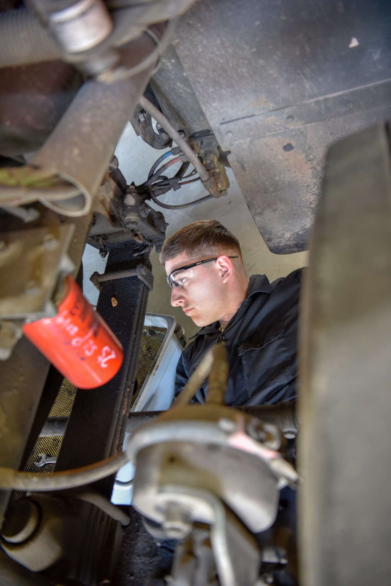 U.S. Air Force Senior Airman Dominic Scully, 8th Logistics Readiness Squadron vehicle maintenance fire and refueling maintenance journeyman, drains engine oil into a pan at Kunsan Air Base, Republic of Korea, April 14, 2020. Scully is one of 48 vehicle maintenance Airmen working to maintain a fleet of over 500 vehicles. (U.S. Air Force photo by Tech. Sgt. Joshua Arends)