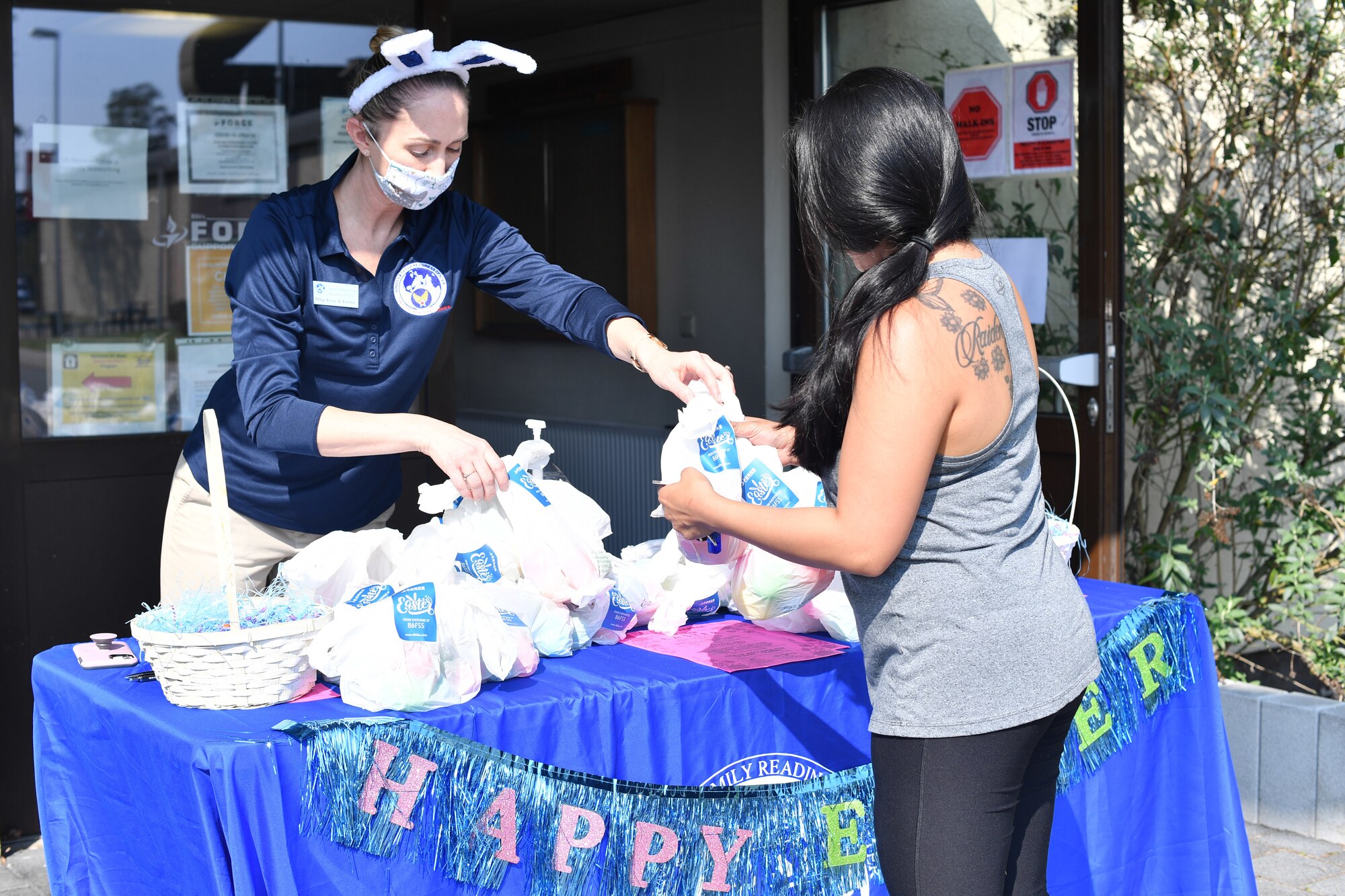 An individual at a booth hands Easter bags to another individual.