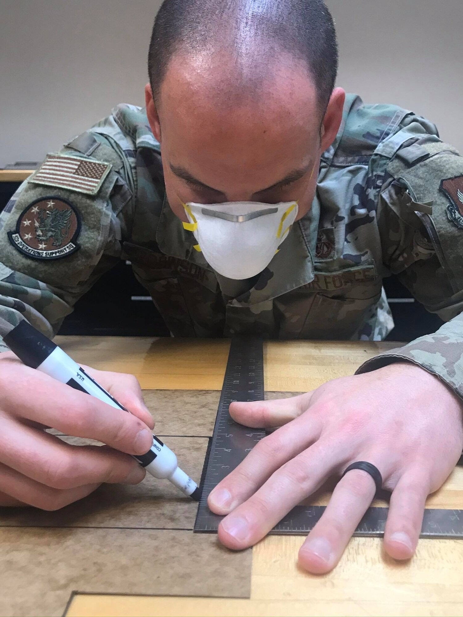 U.S. Air Force Tech Sgt. Kevin Robinson, 52nd Operations Support Squadron NCOIC of aircrew flight equipment quality assurance, outlines a face mask at Spangdahlem Air Base, Germany, April 13, 2020. Robinson’s 52 OSS team has made over 50 masks so far, with an end goal of creating more than 1,500 masks to provide to people in need. Public health protection is the 52nd Fighter Wing’s top priority, and the wing continues to ensure that personnel and community members have the most up-to-date information on appropriate measures to prevent potential spread of COVID-19. (52nd Operations Support Squadron courtesy photo)