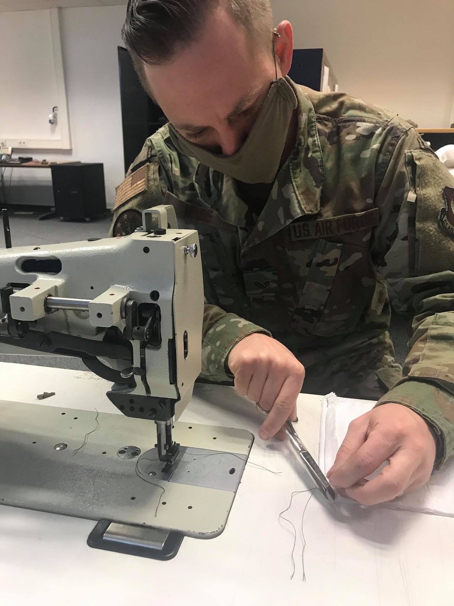U.S. Air Force Staff Sgt. Jacob Wade, 52nd Operations Support Squadron NCOIC of aircrew flight equipment main shop, sews face masks at Spangdahlem Air Base, Germany, April 13, 2020. Wade and U.S. Air Force Tech Sgt. Kevin Robinson, both 52nd OSS members, try to use their time to complete as many face masks as possible. The 52nd Fighter Wing is doing everything possible to help minimize the spread of COVID-19 and is committed to limiting the spread in both the on and off-base community. (52nd Operations Support Squadron courtesy photo)