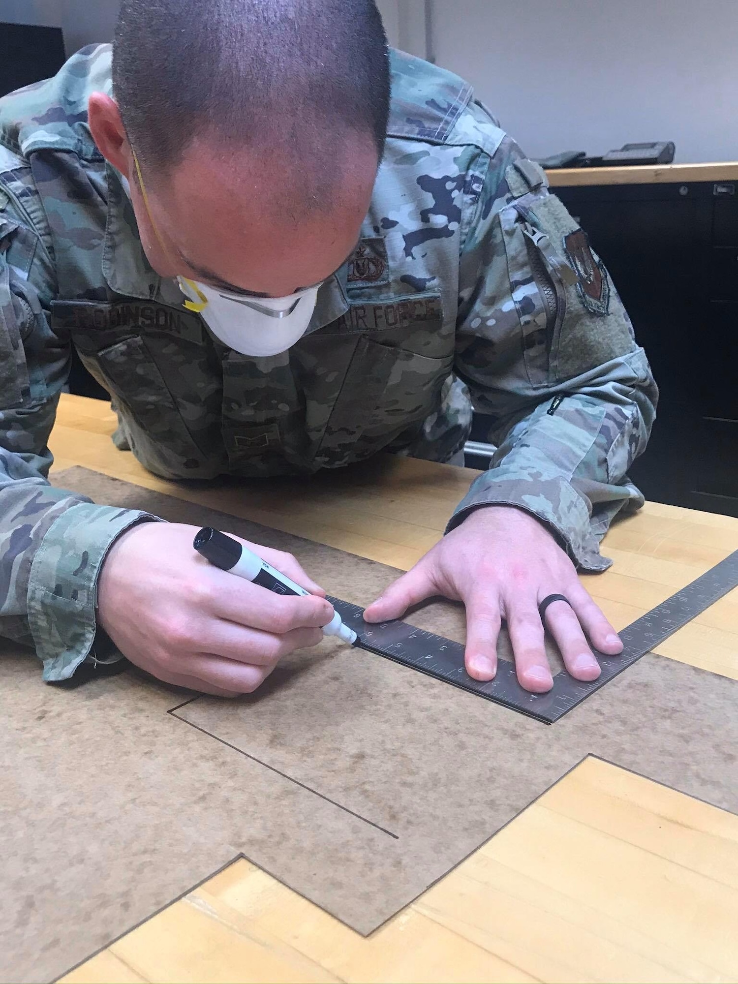 U.S. Air Force Tech Sgt. Kevin Robinson, 52nd Operations Support Squadron NCOIC of aircrew flight equipment quality assurance, makes an outline for face masks at Spangdahlem Air Base, Germany, April 13, 2020. Robinson says he has the skills, tools, and ability to make masks, so he wants to help out the base and local community as much as he can. Public health protection is the 52nd Fighter Wing’s top priority, and the wing continues to ensure that personnel and community members have the most up-to-date information on appropriate measures to prevent potential spread of COVID-19. (52nd Operations Support Squadron courtesy photo)