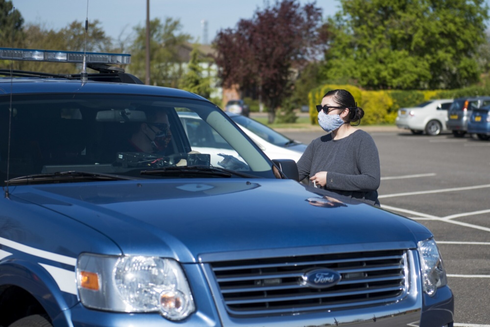 Kristin Joy, a volunteer, hands a cloth face mask at a drive thru at RAF Alconbury, England, April 15, 2020. Volunteers made 232 cloth face masks, which were given to community members to prevent the spread of COVID-19. (U.S. Air Force photo by Airman 1st Class Jennifer Zima)