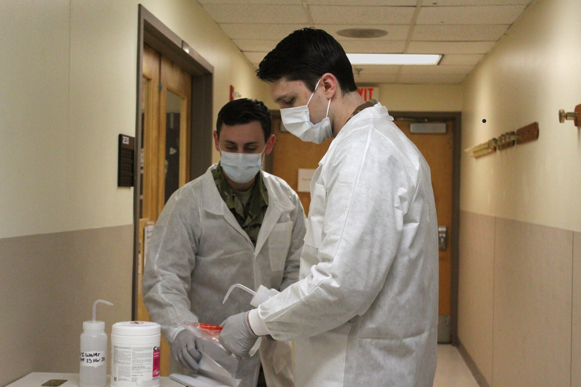 Senior Airman Brian Holloway and Staff Sgt. Gregory Railey decontaminate COVID-19 specimens collected from the 88th Medical Group testing site before login at microbiology and transport to the 711th Human Performance Wing's Epidemiology Lab at the United States Air Force School of Aerospace Medicine (USAFSAM). (U.S. Air Force photo/Kristen Van Wert)