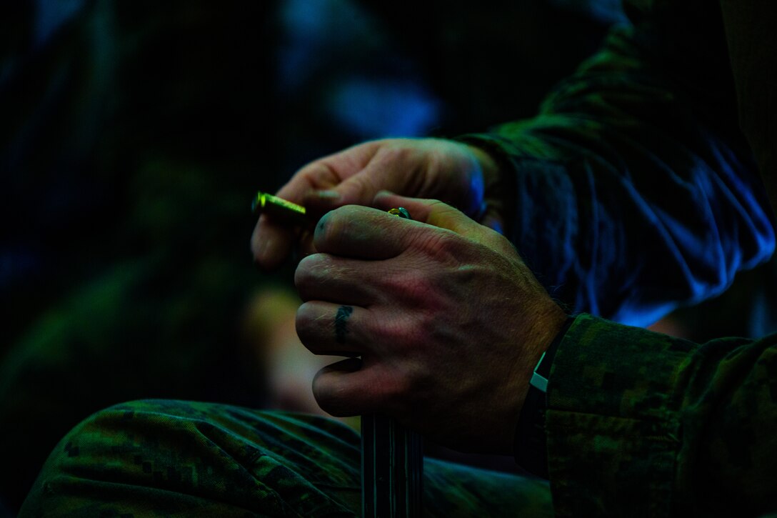 A Marine loads a magazine prior to a fast rope and deck shoot rehearsal aboard amphibious assault ship USS America (LHA 6).