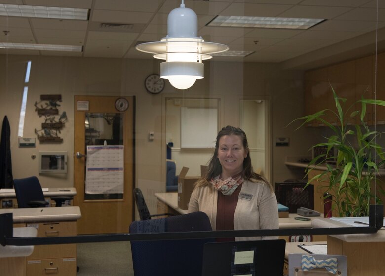 PETERSON AIR FORCE BASE, Colo. – Lindsey Campbell, operations clerk at the Peterson East Child Development Center, works at the front desk behind a plexiglass window April 8, 2020, on Peterson Air Force Base, Colorado. In an effort to reduce the spread of germs, the 21st Civil Engineer Squadron structures recently installed plexiglass panels around Peterson AFB such as, the CDC’s, visitor center, military personnel flight and the United States Space Force and Northern Command Headquarters. (U.S. Air Force photo by Airman 1st Class Andrew Bertain)