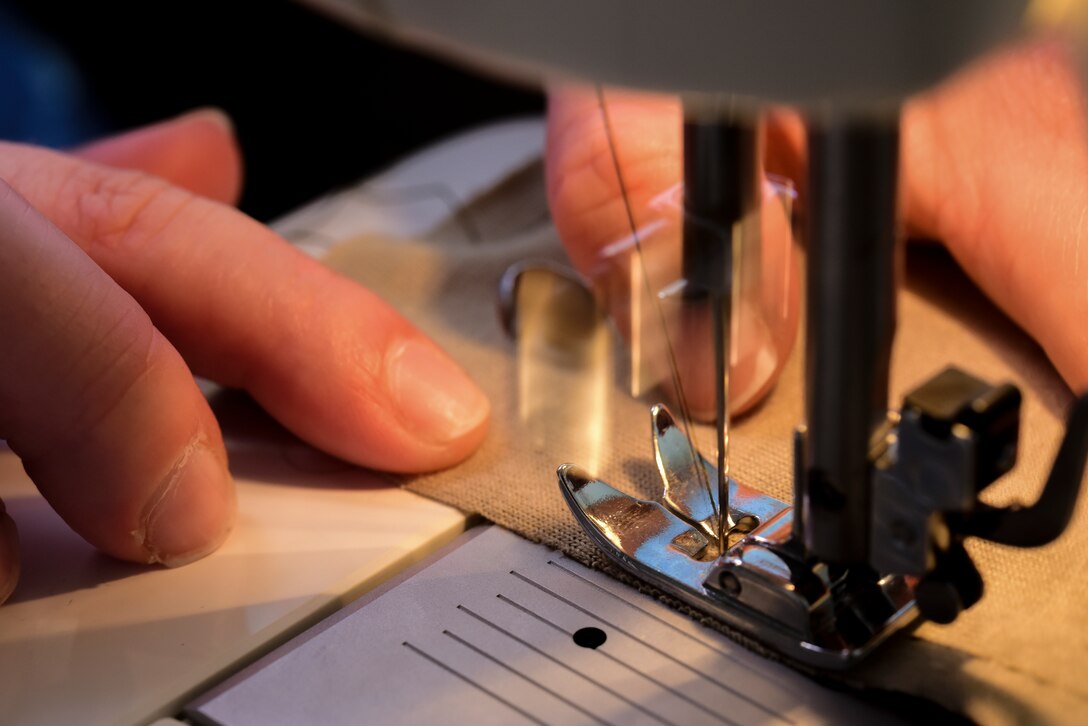 Chelsea Truster, St. James Episcopal Pre-K teacher and Laughlin spouse, stitches a pattern for a protective face mask at her friend’s home on base on April 10, 2020. Becoming ever more familiar with her sewing machine, she’s discovered referring to YouTube can often help her solve issues with her machine when they occur. (U.S. Air Force Photo by Senior Airman Anne McCready)