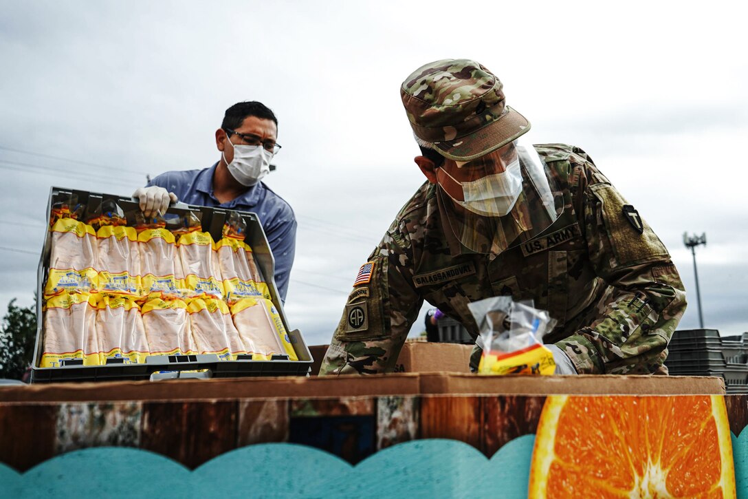 Guardsmen organize food at a food bank.