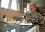 A sailor sits with a meal.
