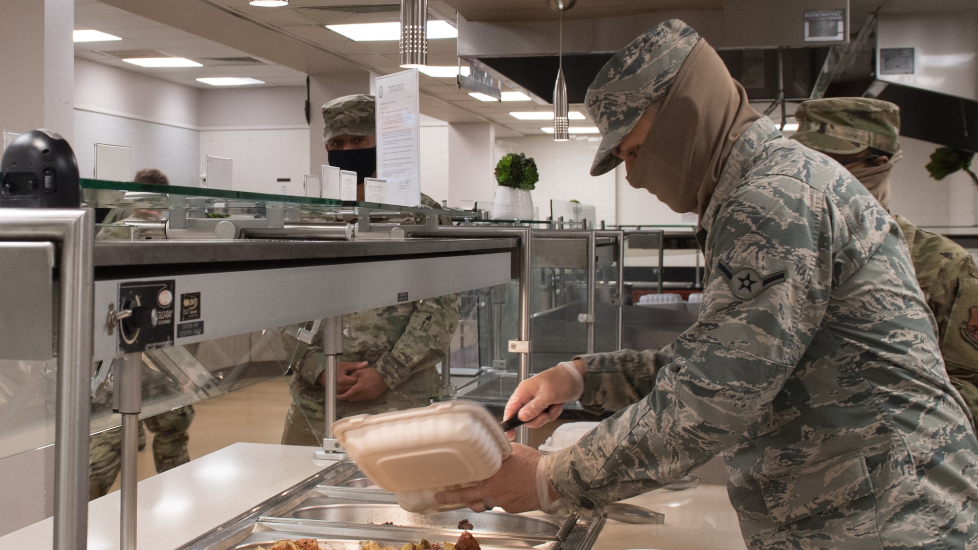 Airman Robert Rivera Sarriera, 2nd Force Support Squadron dining facility shift worker, prepares a meal for a customer at Barksdale Air Force Base, La., April 15, 2020. All food items are currently being made to go. (U.S. Air Force photo by Tech. Sgt. Daniel Martinez)