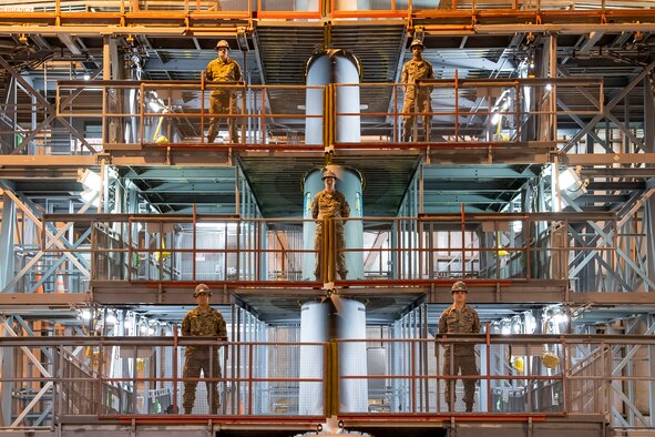 Five 436th Maintenance Squadron aircraft maintenance personnel pose for a group photo in the Isochronal Inspection Dock on Dover Air Force Base, Delaware, April 10, 2020. Dover AFB maintenance personnel continue to support operations despite significantly reduced manning and increased health protection measures such as wearing cloth masks, social distancing, and wash or sanitizing hands frequently to mitigate the spread of COVID-19. (U.S. Air Force photo by Senior Airman Christopher Quail)