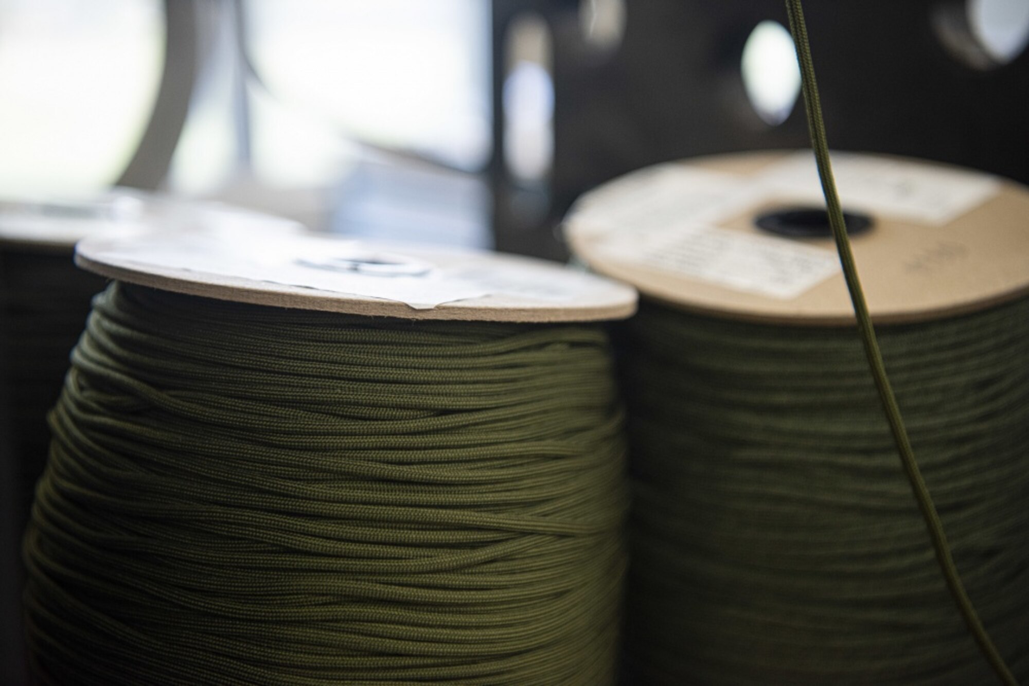Members use 550 cord, as well as cotton fabric to make masks for hospital workers and base members April 14, 2020, at Vandenberg Air Force Base, Calif. As of April 6, 2020, in response to the COVID-19 pandemic, base members are required to wear a mask in buildings and when they are unable to maintain 6 ft. social distancing. To assist with the need for face masks, volunteers from across base have utilized the Training Device Design and Engineering Center to sew masks for base members and hospital workers (U.S. Air Force photo by Airman 1st Class Hanah Abercrombie)