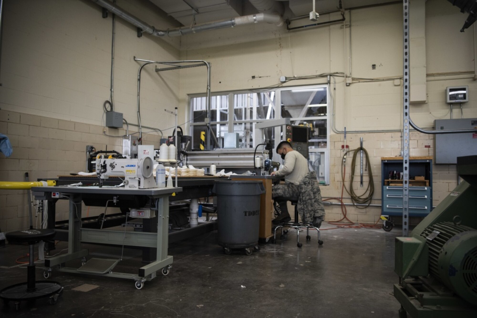 Senior Airman Miguel Garcia, 30th Operations Support Squadron intelligence analyst, sews masks for hospital workers and base members April 14, 2020, at Vandenberg Air Force Base, Calif. As of April 6, 2020, in response to the COVID-19 pandemic, base members are required to wear a mask in buildings and when they are unable to maintain 6 ft. social distancing. To assist with the need for face masks, volunteers from across base have utilized the Training Device Design and Engineering Center to sew masks for base members and hospital workers. (U.S. Air Force photo by Airman 1st Class Hanah Abercrombie)