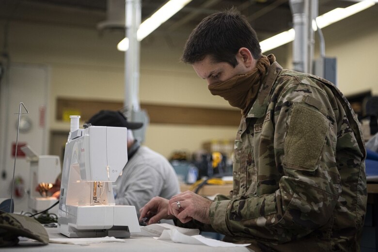 Capt. Daniel Smith, 30th Space Wing launch weather officer, sews masks for hospital workers and base members April 14, 2020, at Vandenberg Air Force Base, Calif. Volunteers from across base have utilized the Training Device Design and Engineering Center to sew masks during the COVID-19 pandemic. As of April 6, 2020, all base members are required to wear mask, so the volunteers began mass producing to help with the mask shortage. (U.S. Air Force photo by Airman 1st Class Hanah Abercrombie)