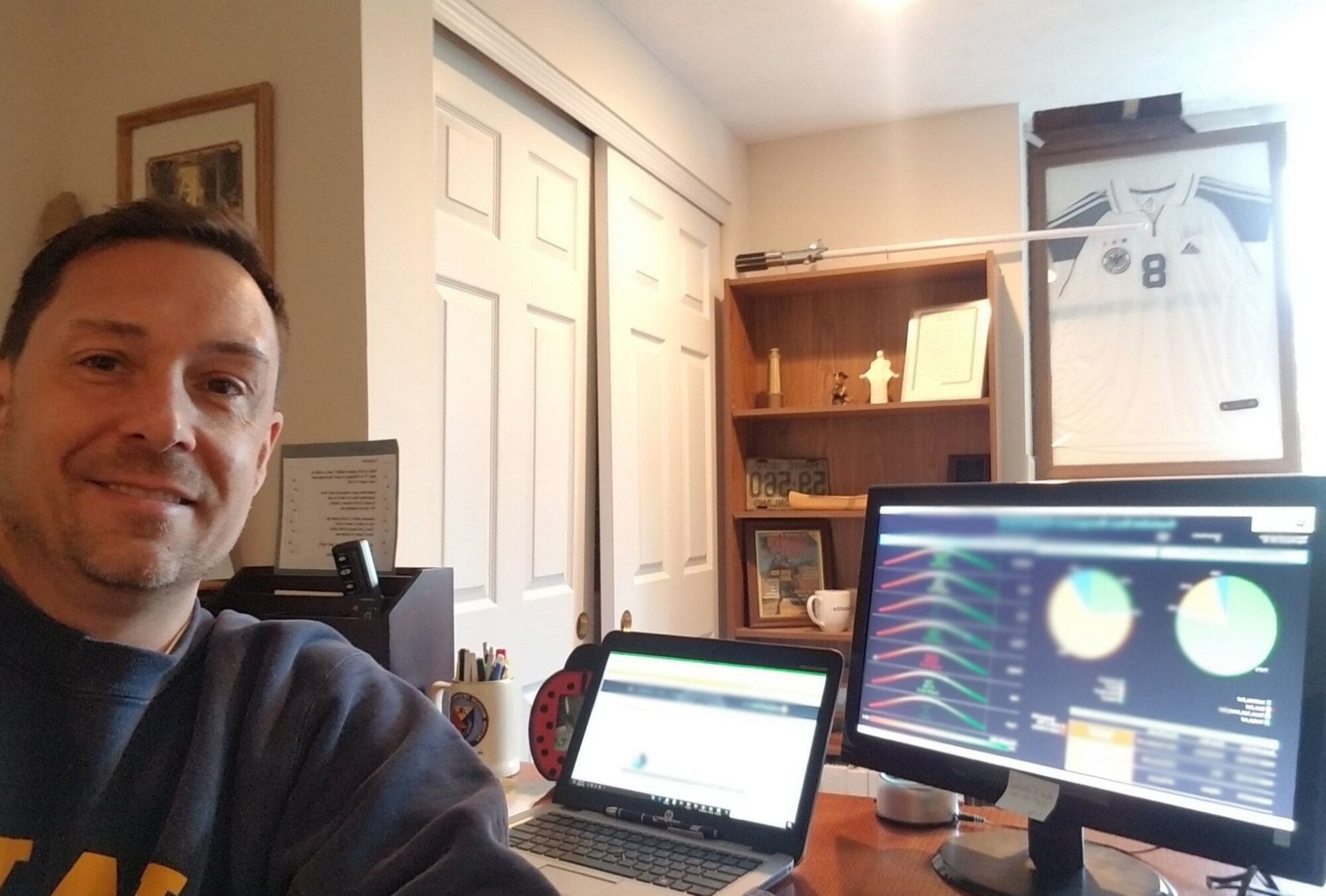 Air Force Installation Contracting Center's Chris Hoff, facilities and construction category management advisor, takes a break from reviewing data in custodial service dashboard in his basement office.