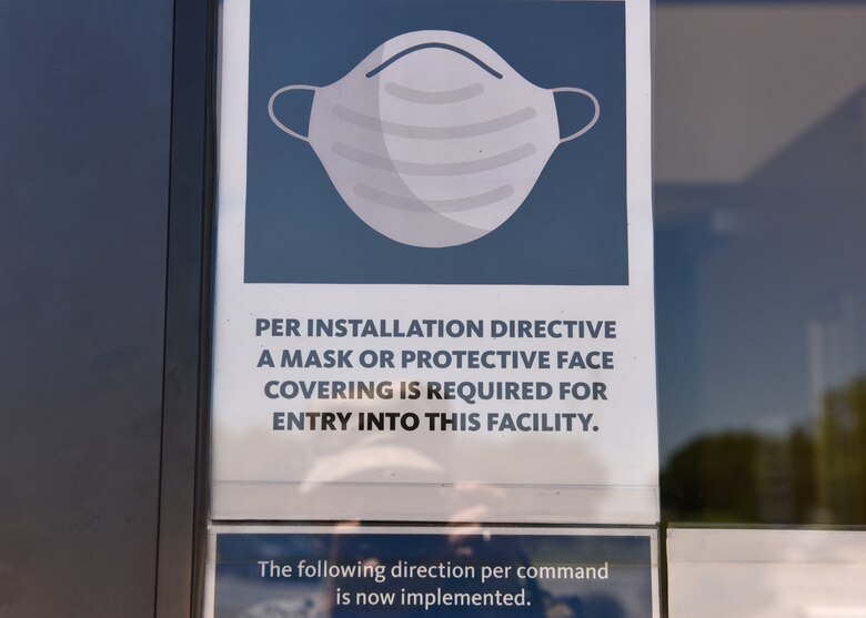 A sign explaining the new safety procedures for shopping at the Base Exchange on Goodfellow Air Force Base is displayed on the door April 16, 2020. Due to COVID-19 precautions are taken and now all customers and employees must be wearing facial masks of some sort to shop. (U.S. Air Force photo by Senior Airman Seraiah Wolf)