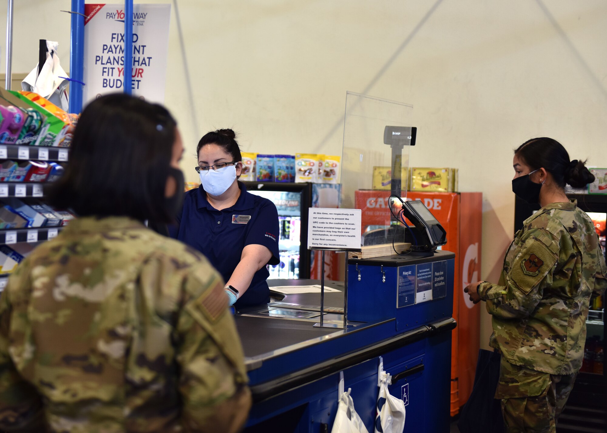 Customers at the Base Exchange on Goodfellow Air Force Base, Texas use proper social distancing and cash out methods while buying their supplies. The Exchange has installed plastic shields at all of their register locations to prevent the spread of COVID-19. (U.S. Air Force photo by Senior Airman Seraiah Wolf)