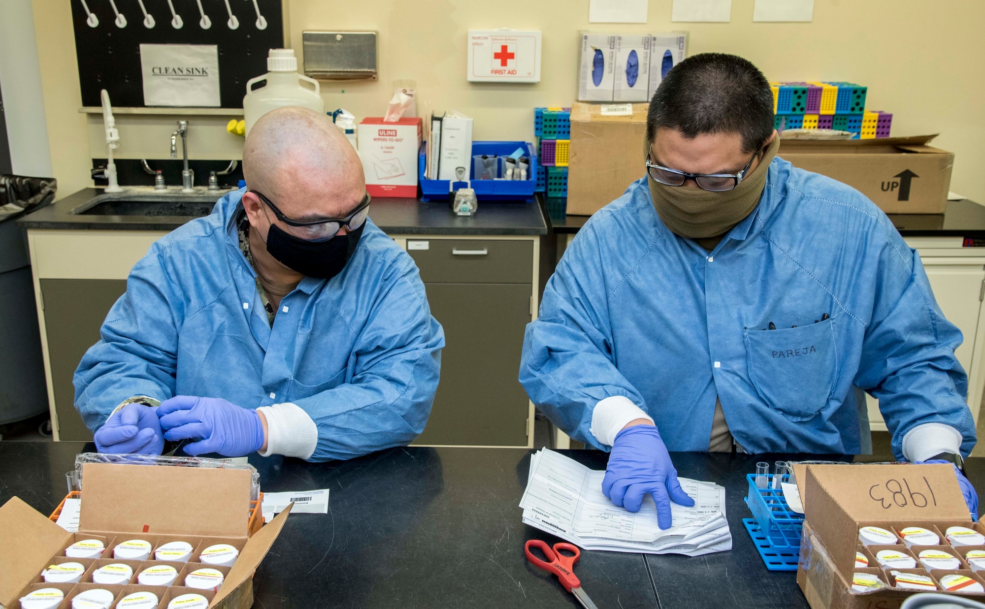 Navy Petty Officer 1st Class Edinmel Balterocruz (left) and Air Force Master Sgt. Jesson Pareja, both Armed Forces Medical Examiner System Forensic Toxicology laboratory technicians, accession samples for testing April 13, 2020. Balterocruz and Pareja and the Division of Forensic Toxicology continue to support national security and combatant commanders through timely and effective testing for the abuse of illicit drug threats. (U.S. Air Force photo by Tech. Sgt. Nicole Leidholm)