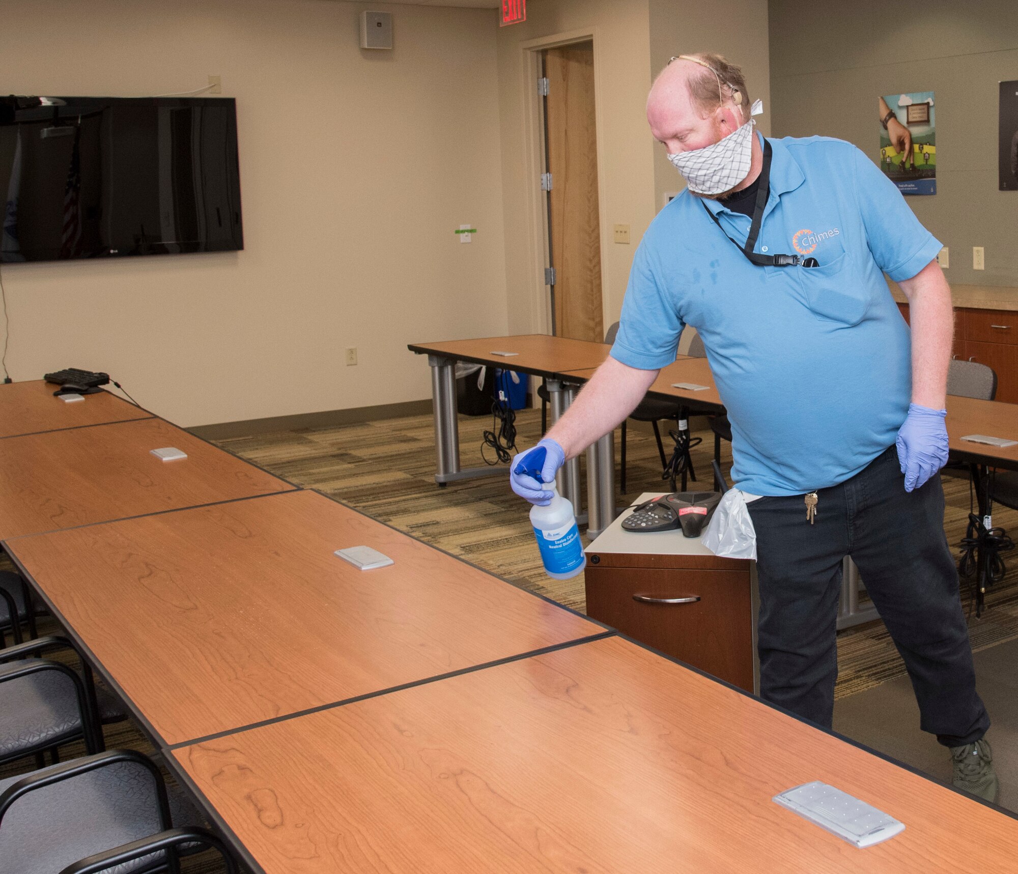 Seth Thomas, Chimes custodian, cleans the AFMES conference room April 9, 2020. Chimes personnel have stepped up their cleaning efforts in the face of COVID-19, taking extra precautions to clean surfaces such as conference room tables by spraying them down with a bleach cleaning solution. (U.S. Air Force photo by Tech. Sgt. Nicole Leidholm)