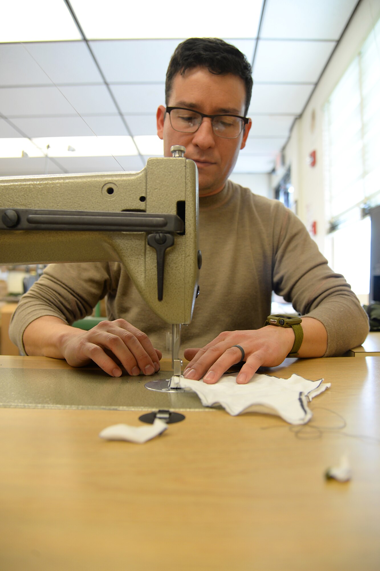 A picture of U.S. Air Force Master Sgt. Kyle P. Brier, an Aircrew Flight Equipment craftsman, sewing face masks.
