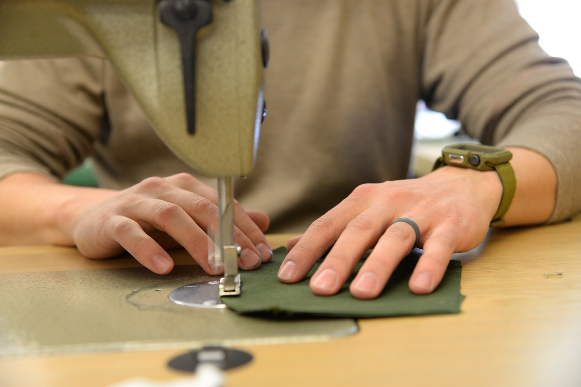 A picture of U.S. Air Force Master Sgt. Kyle P. Brier sewing face masks.