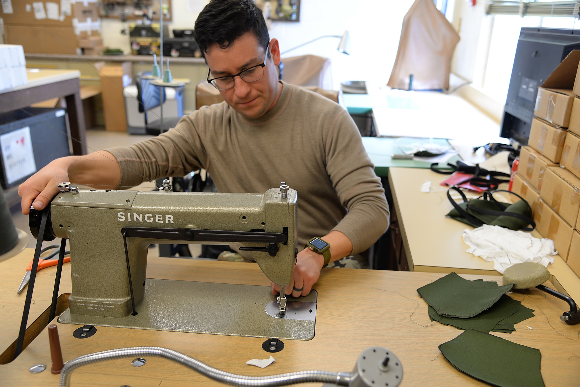 A picture of U.S. Air Force Master Sgt. Kyle P. Brier, an Aircrew Flight Equipment craftsman, sewing face masks.