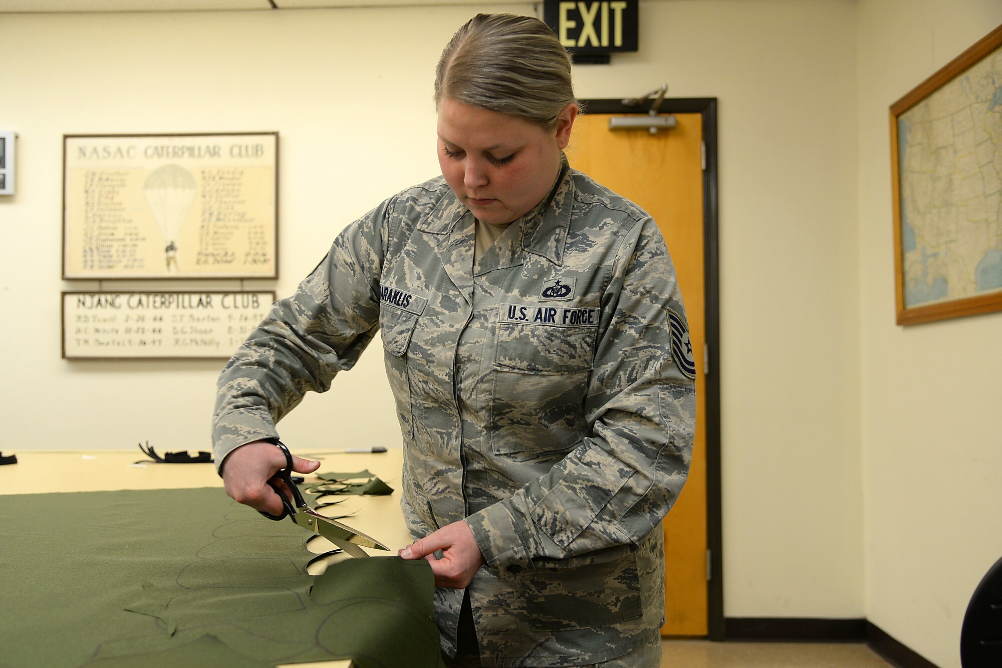 A picture of U.S. Air Force Tech. Sgt. Ashley N. Daraklis, an aviation resource manager, volunteering to prepare fabric for face masks.