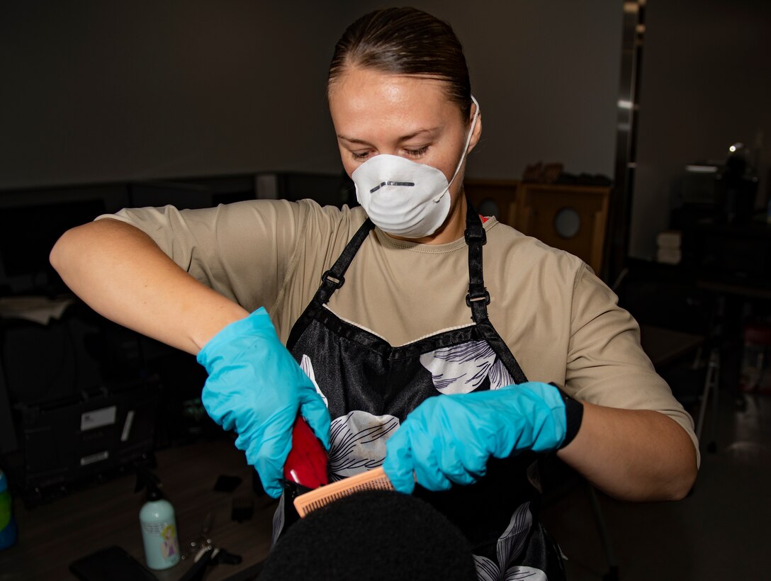 Senior Airman Sara Gutherie, 911th Aircraft Maintenance Squadron instruments and controls technician, cuts a fellow Airman’s hair at the Pittsburgh International Airport Air Reserve Station, Pennsylvania, April 9, 2020.