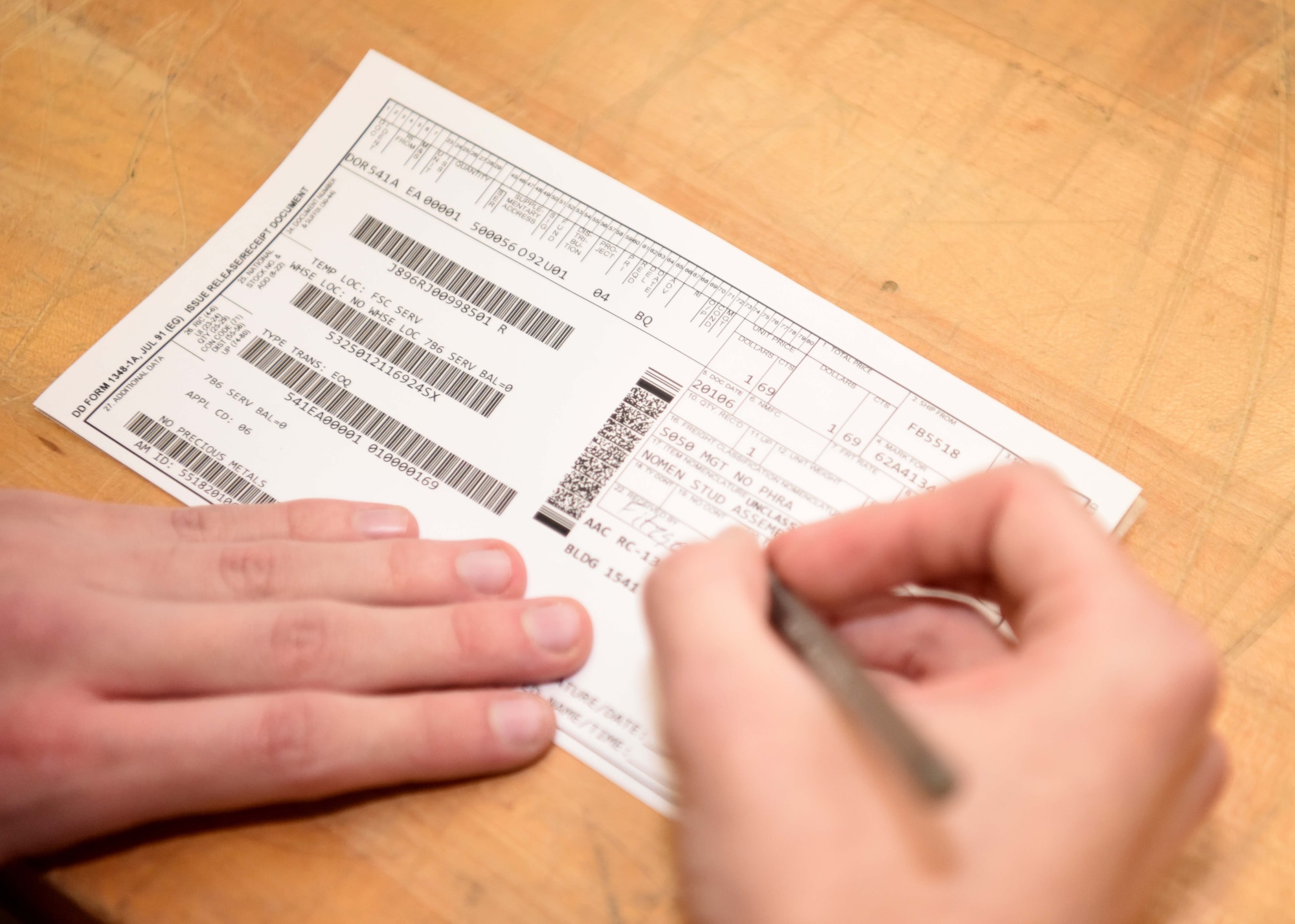 Airman 1st Class Patrick Fitzgerald, 100th Logistics Readiness Squadron flight service center, fills out a DD Form 1348 which helps maintain accountability of the aircraft parts that make their way to maintenance squadrons at RAF Mildenhall, England, April 15, 2020. The FSC supports maintenance by providing control of all items requiring replacement. (U.S. Air Force photo by Senior Airman Brandon Esau)