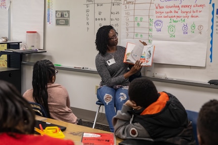 Norfolk Naval Shipyard employee Sandra Demetrius shares a favorite story from her childhood during Read Across America Day at James Hurst Elementary School Mar. 2.