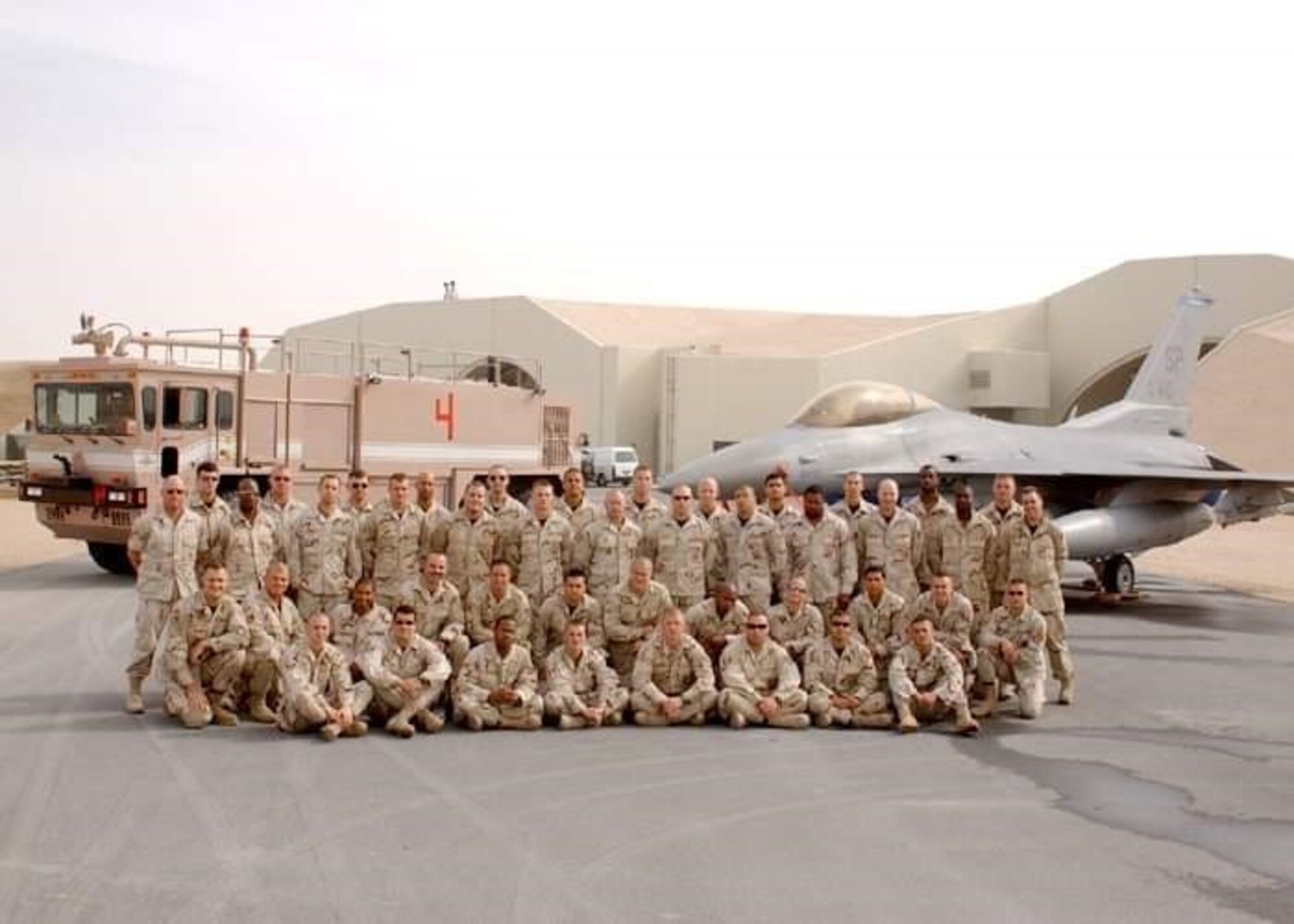 Then U.S. Air Force Master Sgt. John Thompson and other deployed firefighters take a group photo at Al Udeid Air Base, Qatar, sometime between Dec. 2002 to July 2003.