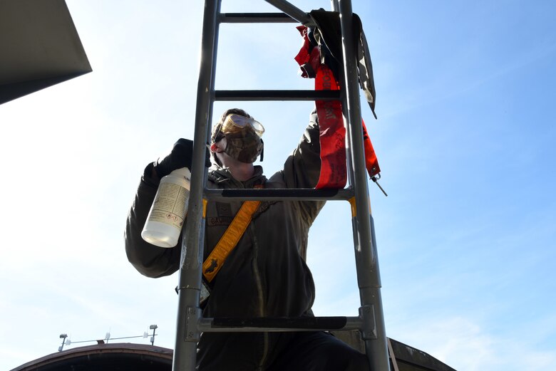 A 493rd Aircraft Maintenance Unit crew chief cleans a ladder to prevent the spread of COVID-19 at Royal Air Force Lakenheath, England, April 15, 2020. The task requires everything inside the cockpit to be sanitized, to include any tool, button or switch the aircrew may have come in contact with during their flight. (U.S. Air Force photo by Airman 1st Class Rhonda Smith)