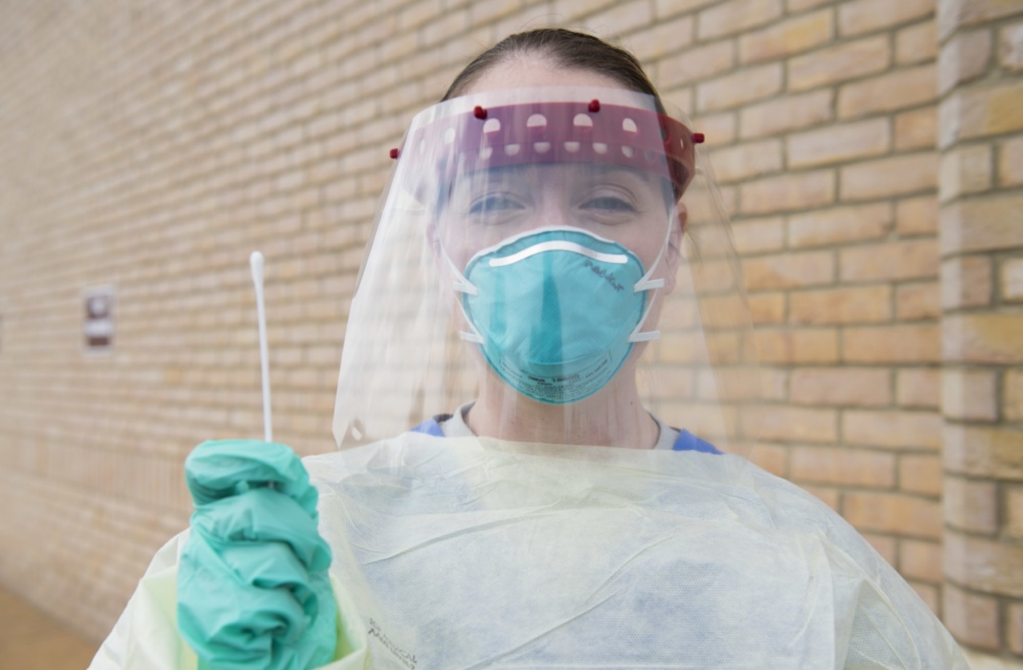 U.S. Air Force Capt. Jennifer Andrews, 423rd Medical Squadron family health clinic element chief, clinical nurse and infection preventionist, poses for a photo as she holds a swab at a COVID-19 drive-up testing station at RAF Alconbury, England, April 13, 2020. The 423rd MDS transformed their parking lot into a drive-thru to expedite testing and prevent the spread of COVID-19. (U.S. Air Force photo by Airman 1st Class Jennifer Zima)