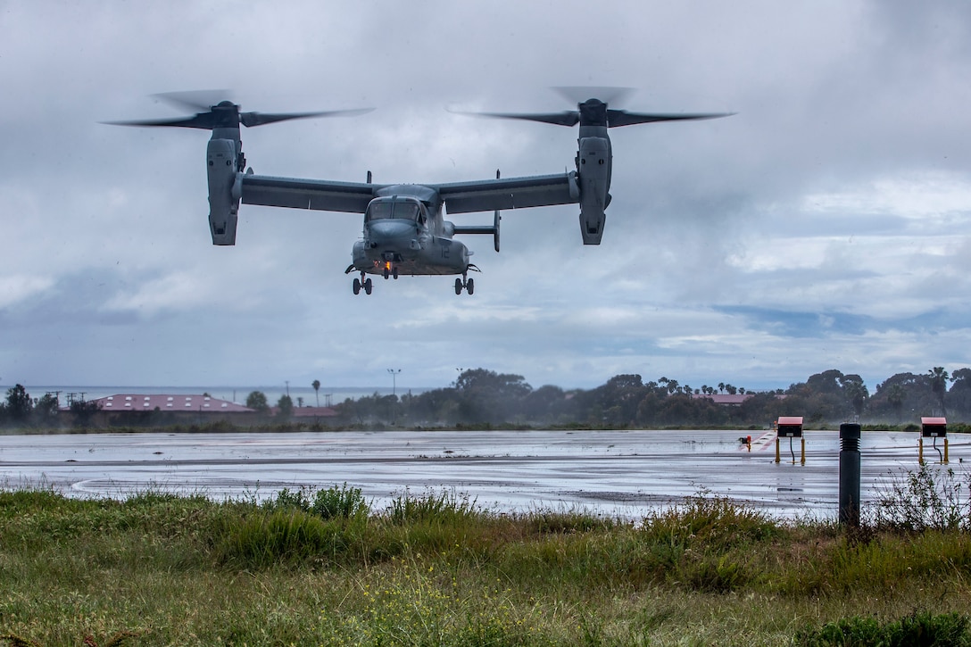 An Osprey aircraft prepares to land on a wet tarmac.