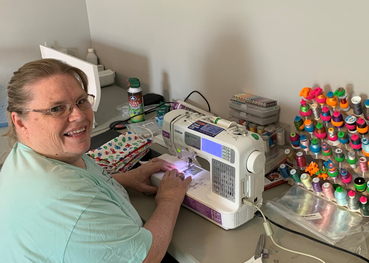 Woman works at sewing machine making face mask