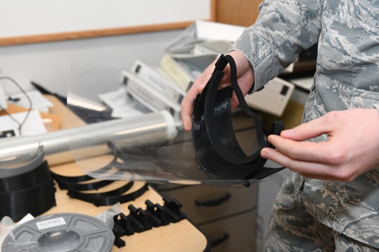 U.S. Air Force Staff Sgt. David Astleford, a 509th Maintenance Group research and engineering computer-aided drafting manager, showcases a 3D printed medical face shield prototype, made by the RE shop at Whiteman Air Force Base, Missouri, April 13, 2020. The RE shop utilized the National Institute of Health’s approved face mask as a model to create their own version of a face shield, featuring an added foam piece on the forehead to provide more comfort and using an adjustable band verses an elastic rubber one. Once approved, they plan on producing more than 300 shields to give to aid in Johnson County, Missouri’s COVID-19 medical efforts. (U.S. Air Force photo by Staff Sgt. Sadie Colbert)