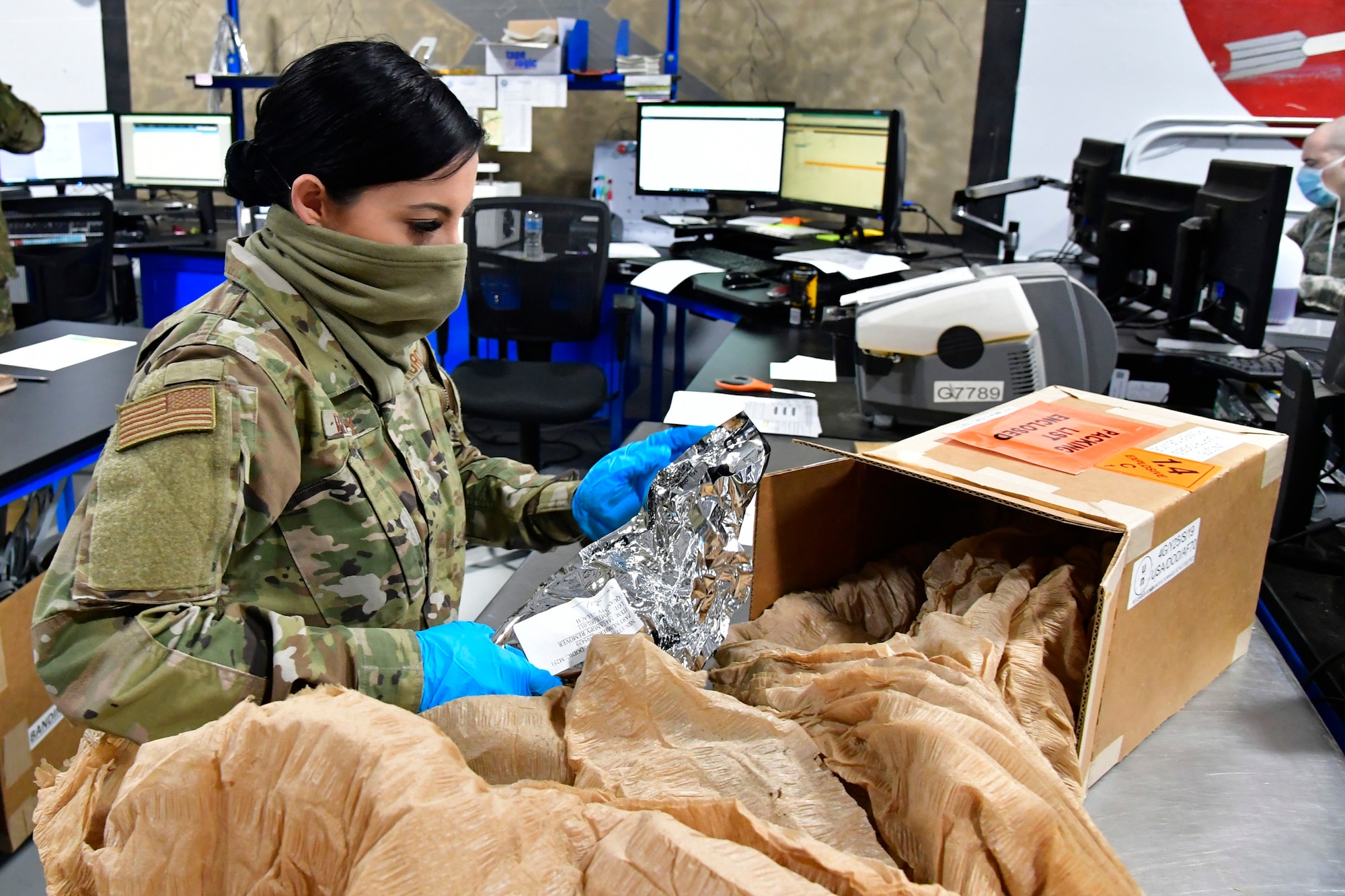 Staff Sgt. Mia Blakley sifting through packaging of a box.