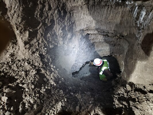 Ryan James, a digging contractor, breaks through into the back of the gravel room for the first time from the new back crosscut in the Cold Regions Research and Engineering Laboratory's Permafrost Tunnel Research Facility in Fox, Alaska. The excavation was part of the phase four expansion of the permafrost tunnel, which added a new 300-foot tunnel and improved 200 feet of the pre-existing tunnel.