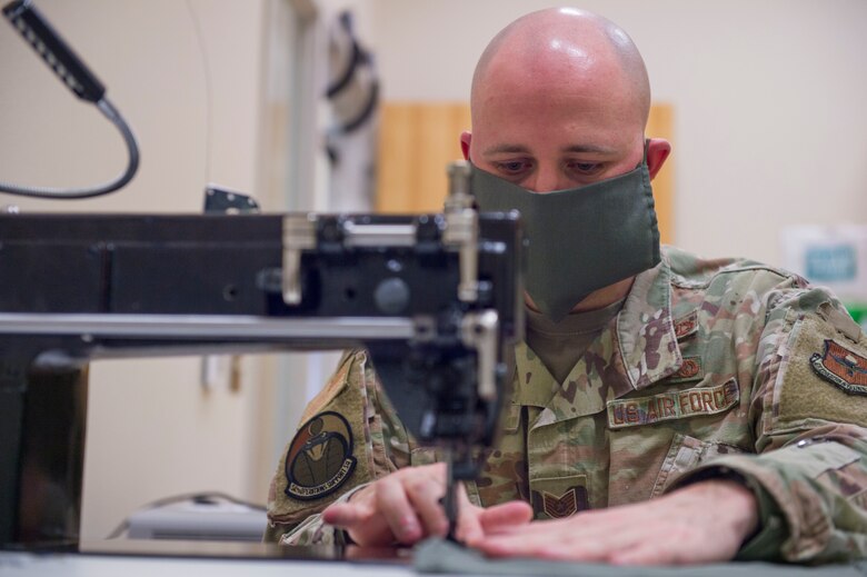 Tech Sgt. Joshua Peninger, 54th Operations Support Squadron Aircrew Flight Equipment Main Shop noncommissioned officer in charge, sews a protective face covering, April 10, 2020, on Holloman Air Force Base, N.M. Since face coverings are required for areas on base where a physical distance cannot be maintained, squadron personnel, spouses and other team members are all contributing by making face coverings for their respective units. The 54th OSS AFE main shop Airmen are using their occupational skills to craft face coverings for their squadron.   (U.S. Air Force photo by Airman 1st Class Quion Lowe)