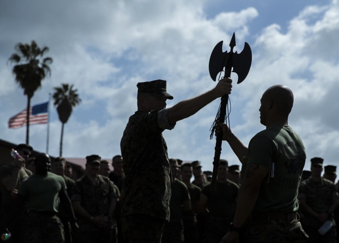 U.S. Marine Corps Sgt. Maj. Ryan W. Meltesen, left, sergeant major of 1st Light Armored Reconnaissance Battalion (1st LAR), 1st Marine Division (1st MARDIV), hands the battle-axe to Capt. Jeshua O. Alston, an infantry officer with 1st LAR, 1st MARDIV, during Warrior Day at Marine Corps Base Camp Pendleton, California, March 13, 2019.