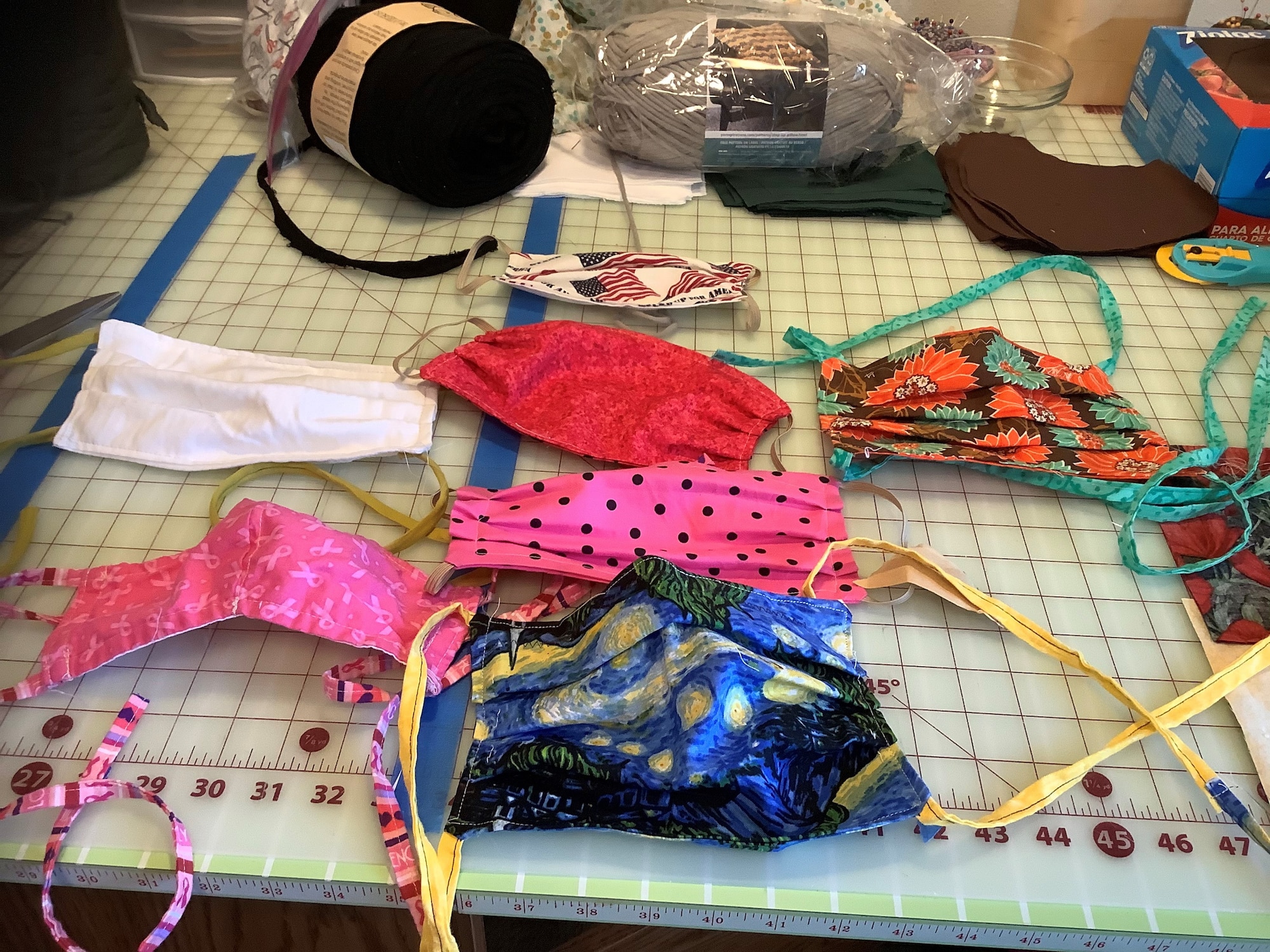 Photo shows multiple fabric masks laid on a table.