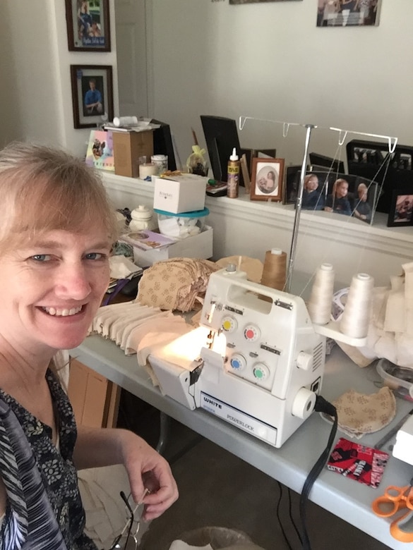 Photo shows Gwen Mueller taking a selfie in front of her sewing machine.