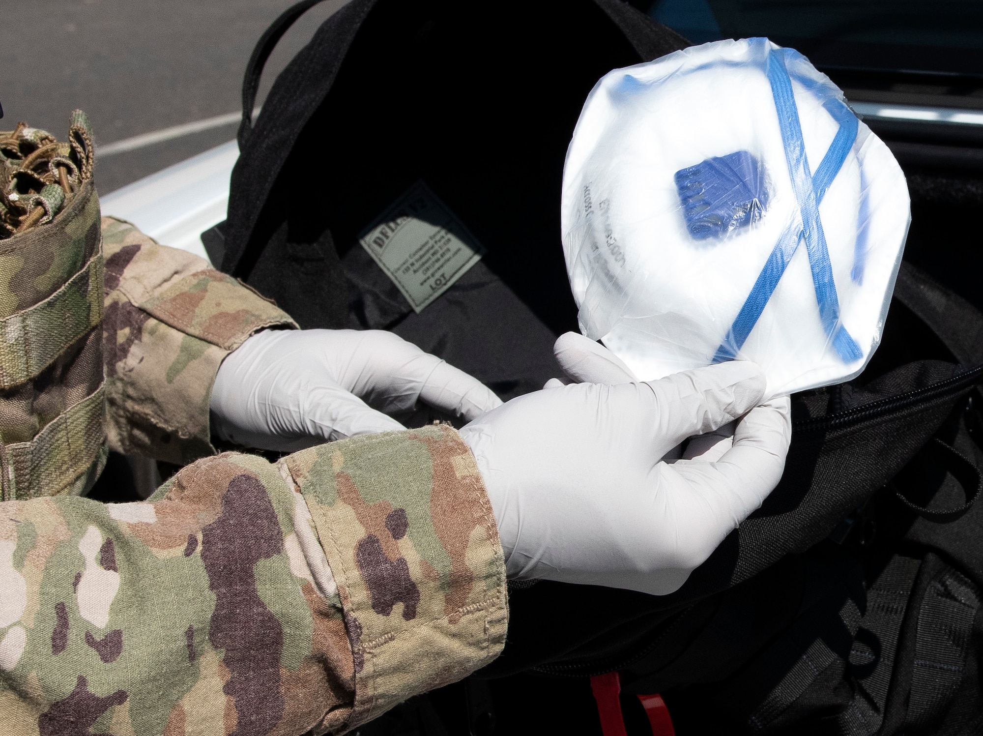 Senior Airman Jeffrey Clark, a 48th Security Forces Squadron response force leader, puts a respirator mask inside a COVID-19 response kit at Royal Air Force Lakenheath, England, April 16, 2020. Due to the nature of their mission, 48th SFS Defenders are equipped to take extra precautions during high-risk situations where they may not be able to maintain proper distance or fully avoid person-to-person contact. (U.S. Air Force photo by Airman 1st Class Jessi Monte)