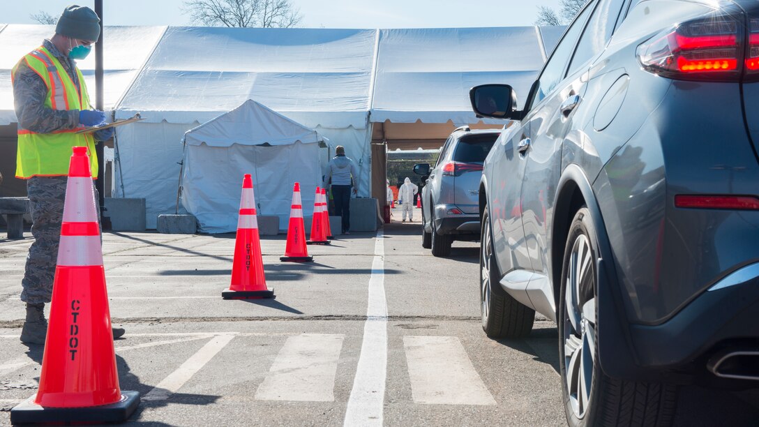 Senior Airman Matt Wysocki, 103rd Air Control Squadron, writes down patient information at a COVID-19 drive-through testing site in New Haven, April 16, 2020. The Connecticut National Guard is providing power generation and access control support to maximize site efficiency.