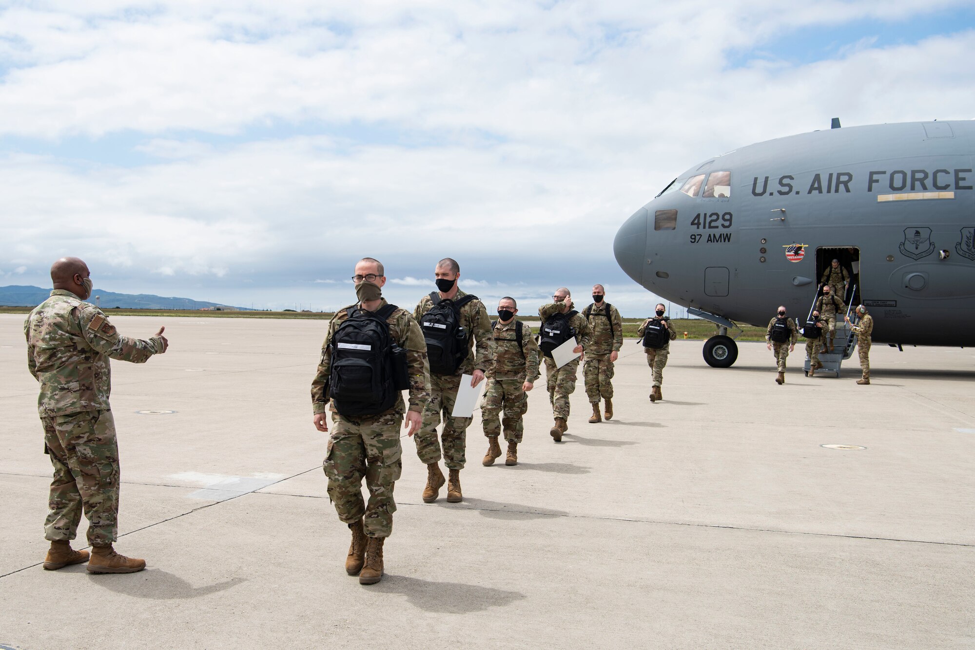 Airmen arriving from Basic Military Training are greeted by Chief Master Sgt. Darryl Hogan, 30th Space Wing command chief, April 17, 2020, at Vandenberg Air Force Base, Calif. In order to safely route members from BMT during the COVID-19 pandemic, the Airmen were flown on a C-17 to the flightline at Vandenberg AFB, and later bussed to their technical school locations. Each Airmen went through a 14-day quarantine process at Joint Base San Antonio-Lackland, Texas, prior to flying on the C-17. (U.S. Air Force photo by Senior Airman Aubree Owens)