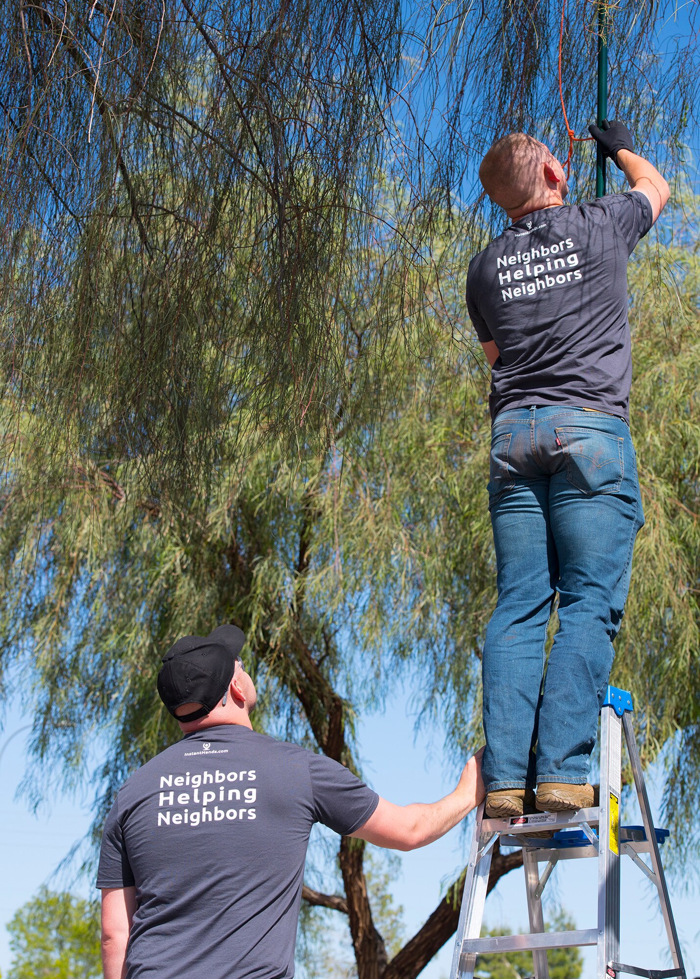 Airman 1st Class Bradley Chitwood, 56th Force Support Squadron food service journeyman (left), and Senior Airman Montana McCormick, 56th Force Support Squadron lead recreational specialist, trim a tree April 1, 2020, in Avondale, Ariz.