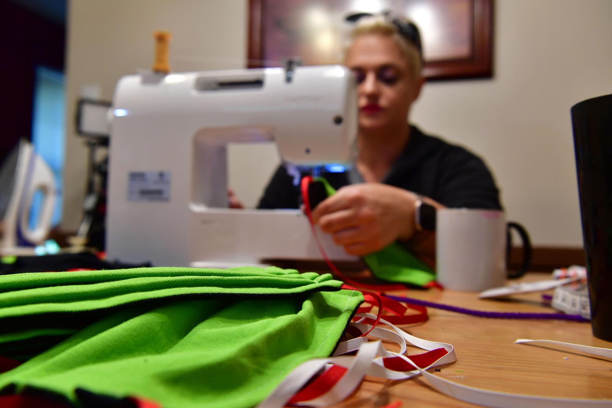 Caitlyn Bowman, spouse of U.S. Air Force Tech. Sgt. Robert Bowman, operates a sewing machine to complete a mask in Jacksonville.