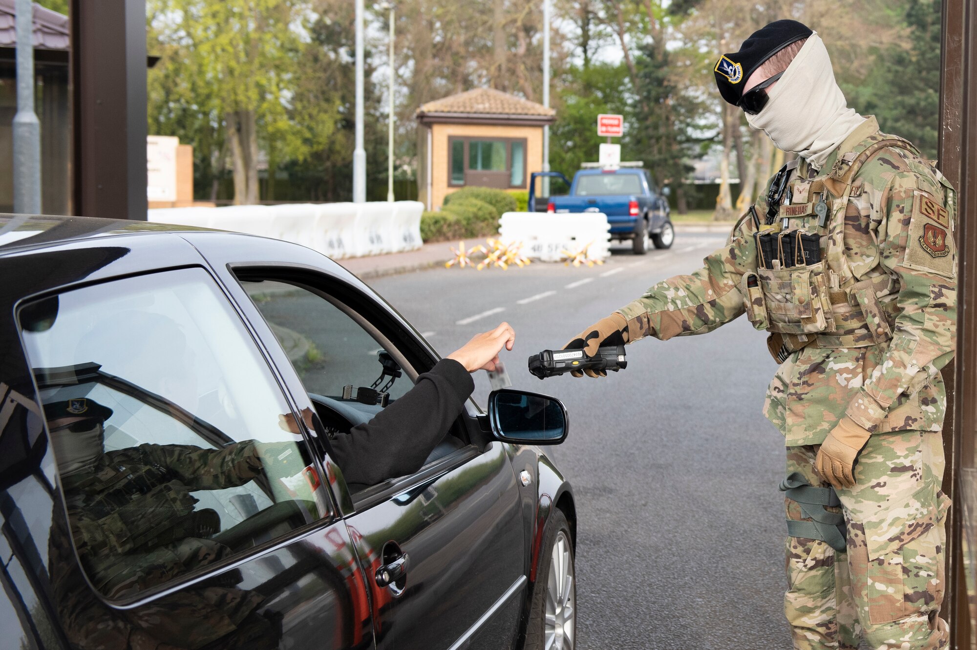 A 48th Security Forces Squadron Airman scans an ID card at the gate at Royal Air Force Lakenheath, England, April 16, 2020. The 48th SFS Defenders have taken preventative measures to combat the spread of COVID-19, such as avoiding unnecessary person-to-person contact by not handling ID cards. (U.S. Air Force photo by Airman 1st Class Jessi Monte)